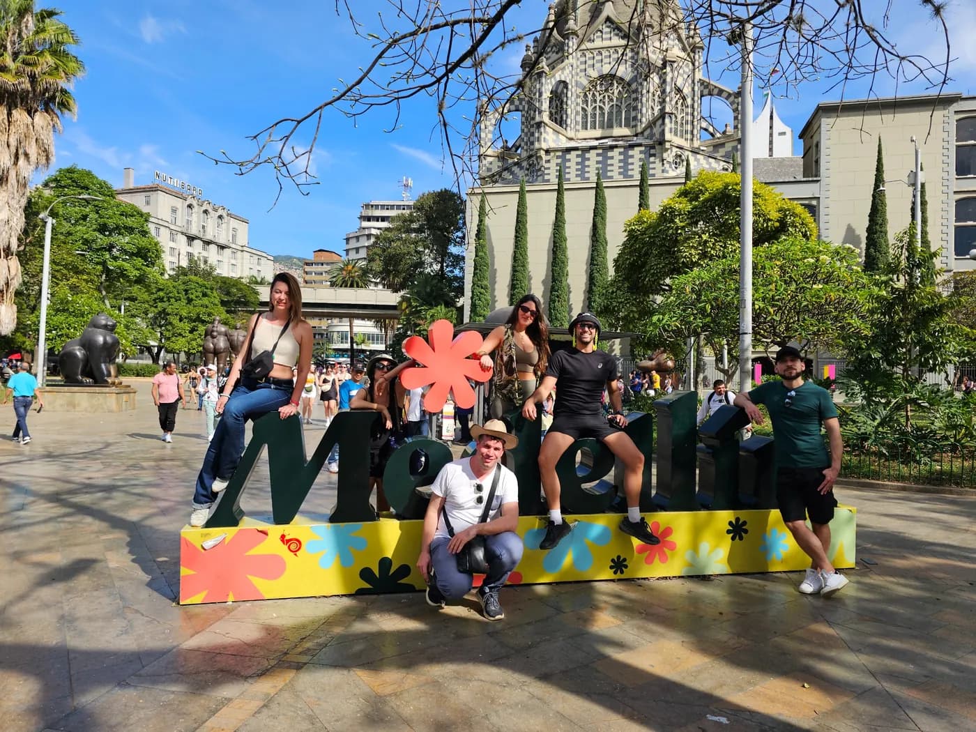 Grupo de viajeros frente a las letras de Medellín