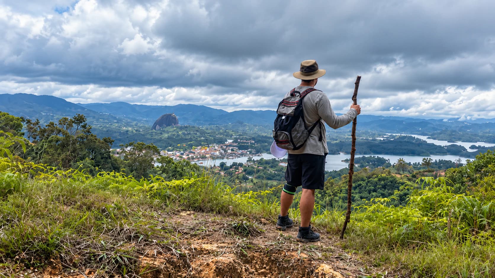 Panoramic view from Mirador San José with a hiker observing the landscape of Guatapé.